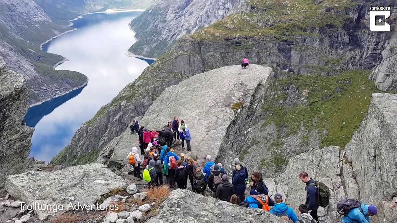 Des randonneurs font la queue pour une photo sur un rocher