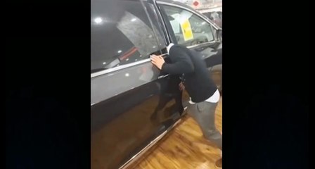 Un vendeur de voitures se coince la tête.