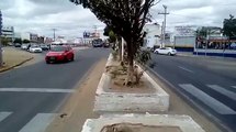 Uma senhora jogando pedra em carros que passavam por uma avenida em Juazeiro-BA