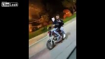 Two people on a motorcycle showing off for the camera crashes into a car door