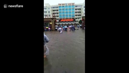 Scooter driver ploughs through elbow-deep water during Storm Haikui