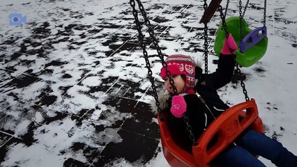 Happy baby enjoying the snow in the park