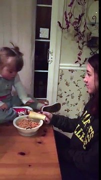 Cette fillette mange les spaghettis à la main dans l'assiette de sa soeur !