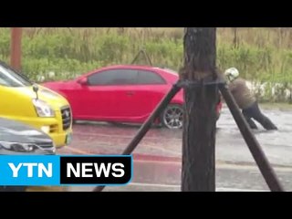 [영상] 소나기에 멈춘 승용차 "내가 밀어줄게요" / YTN