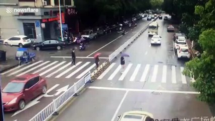 Driver blocks traffic to make way for elderly woman crossing road