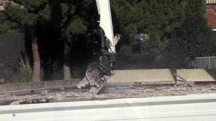 La grue découpe le toit petit à petit.