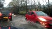 Cars plough through flooded roads in Cumbria