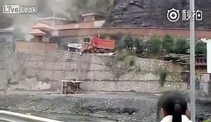 Un ouvrier mécontent pousse un camion et deux voitures dans un ravin