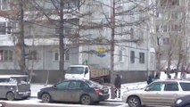 Des russes chargent un camion depuis le toit d'un immeuble