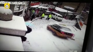Taxi slips and slides crashing into a police officer
