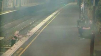 Une femme ivre traverse une voie ferrée