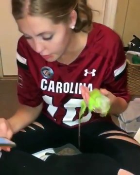 Une fille tire la langue à un iguane