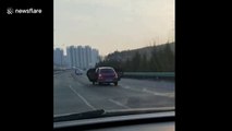 Car drives along motorway with both back doors OPEN
