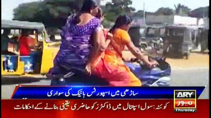 Indian woman rides a bike wearing saree