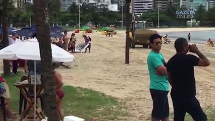 Tratores trabalham no meio dos banhistas na Curva da Jurema