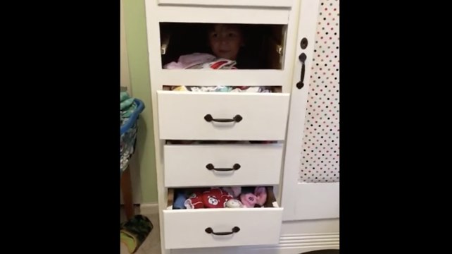 Coincé derrière les tiroirs d'un meuble ce gamin ne sait pas en sortir !