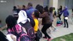 Grown men struggle to control young girls wanting to fight at a Dallas middle school