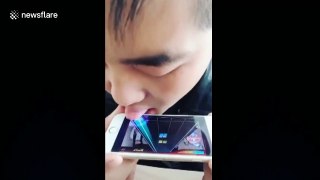 Man plays mobile music game with tongue