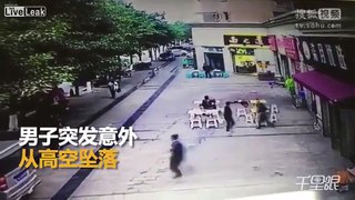 Man falls from the sky near a group of people eating