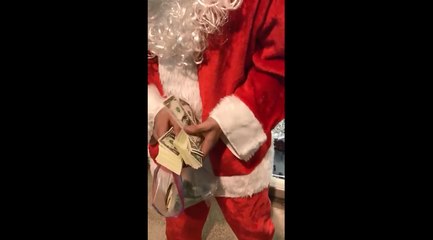 Un père noël jette 1000 dollars dans un centre commercial.