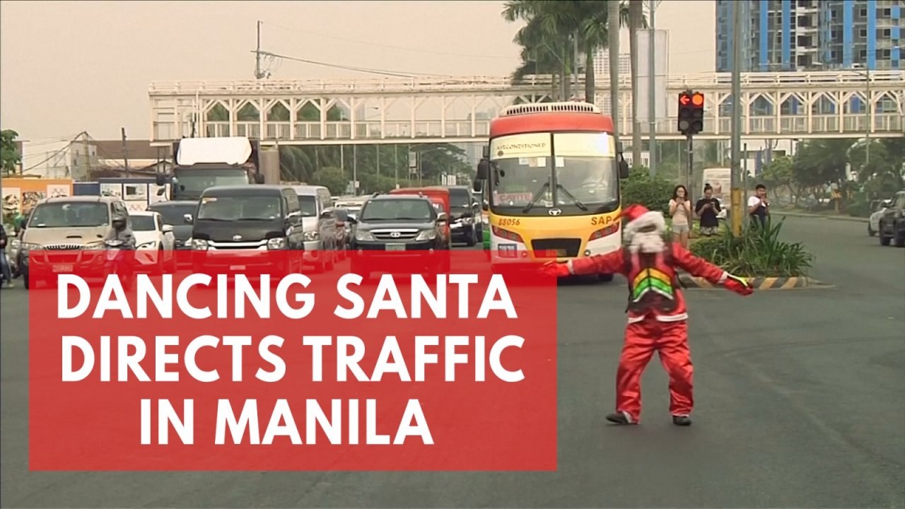 Dancing Filipino traffic cop in Santa Claus cos...