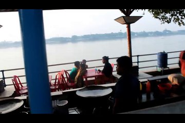people are eating fast food in the restaurant beside the ganga river