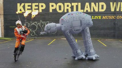 Un homme en monocycle fait tomber un AT-AT