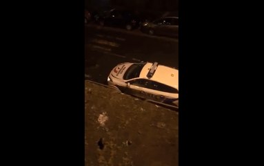 Il lance une bûches de bois sur le toit d'une voiture de police.