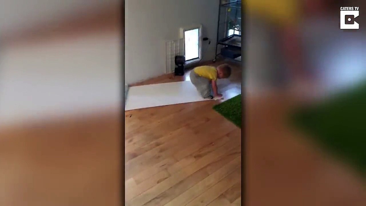 Cet enfant essaye de garder plat un papier de noel au sol et n'y arrive pas !