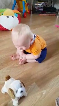 Ce bébé aime tellement son nouveau jouet... Il en est plié de rire