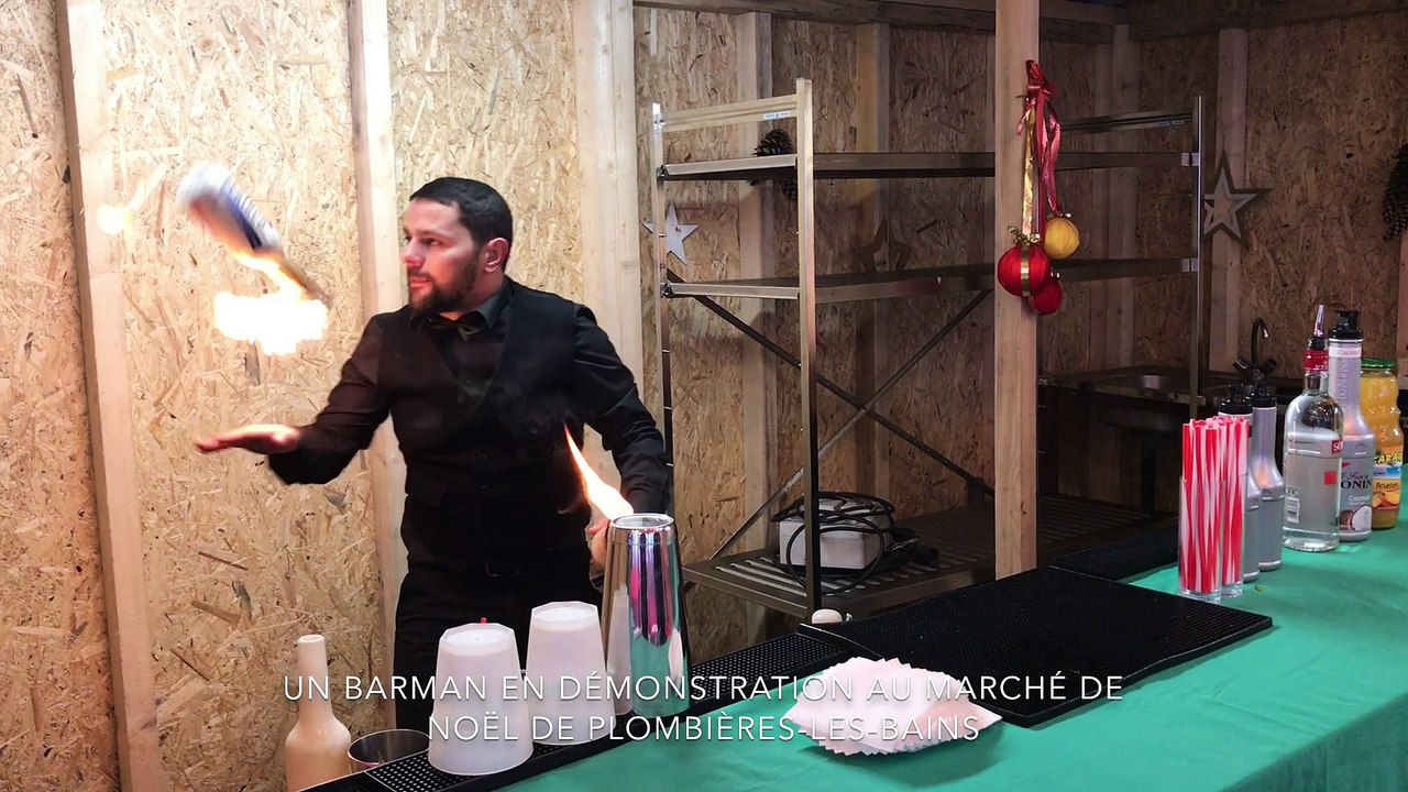 Un barman jongle avec des bouteilles enflammées au marché de Noël de Plombières-les-Bains