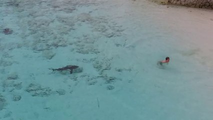 Des curieux s'approchent d'un enfant qui saute dans l'eau