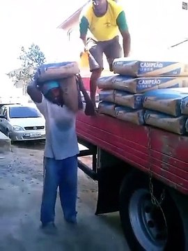 Ce gars costaud porte des sacs de ciment cinq par cinq, poids de 250 kg