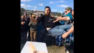 Deux hommes lancent un supporter sur une table en feux.