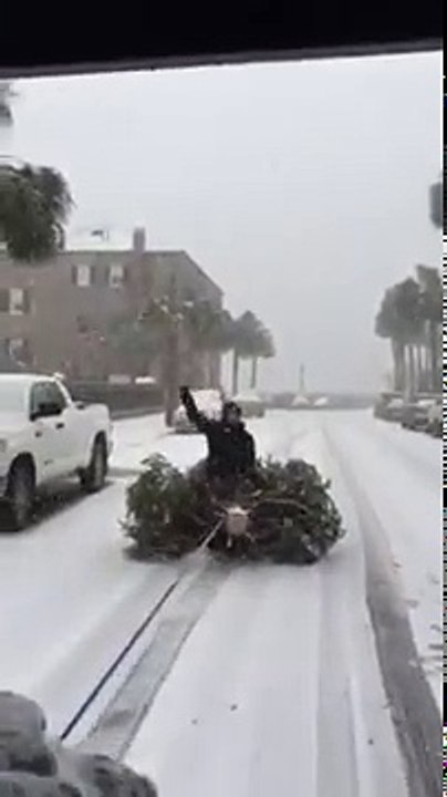 Un gars sur un sapin se fait tracter par un véhicule