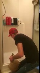 Il essaie de nous montrer comment retirer la touffe de cheveux coincé dans le siphon de la douche