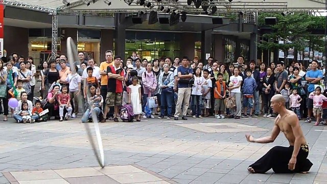 Un artiste asiatique réalises des acrobaties avec son cerceau géant