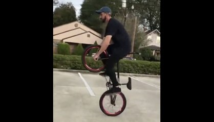 Il roule en Vélo BMX... Assis sur l'axe du guidon à la verticale !