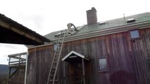 Sweeping the chimney on a slate roof