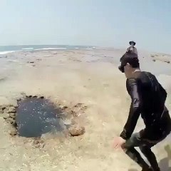 Ils sautent dans un trou sur la plage et ressortent un peu plus loin