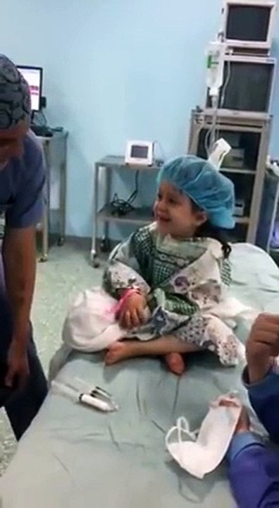 Le geste tendre que le medecin fait à la fillette avant son opération
