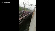 Mumbai commuters clamber out of train and over collapsed bridge