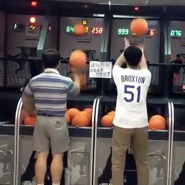 Un homme enchaîne les paniers des deux mains à la fête foraine à une vitesse folle