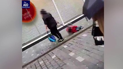 Une maman traine son fils avec une laisse dans la rue...