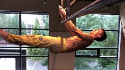 Ce gymnaste tient en équilibre à l'horizontal suspendu à un anneau en équilibre !