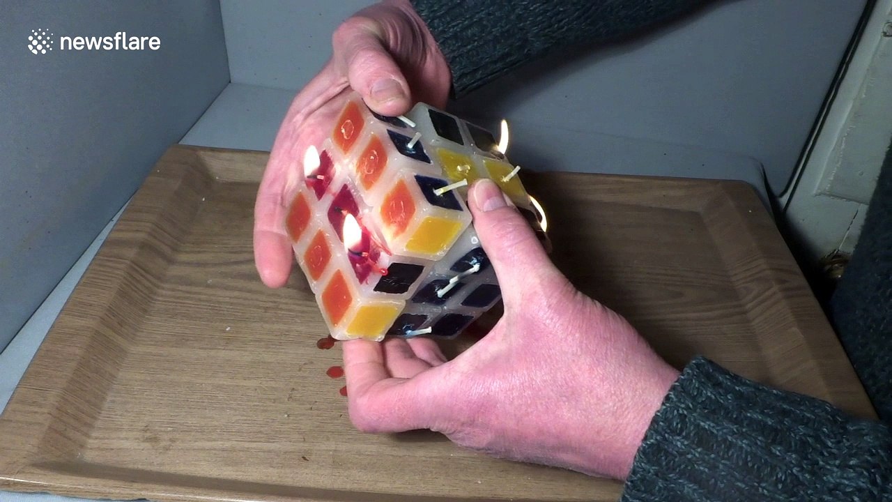 Man plays with burning candle Rubik's Cube