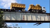 Ce camion roule sur un pont... ferroviaire sur les rails du train en équilibre !