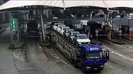 Overloaded truck knocks over toll booth with collector inside