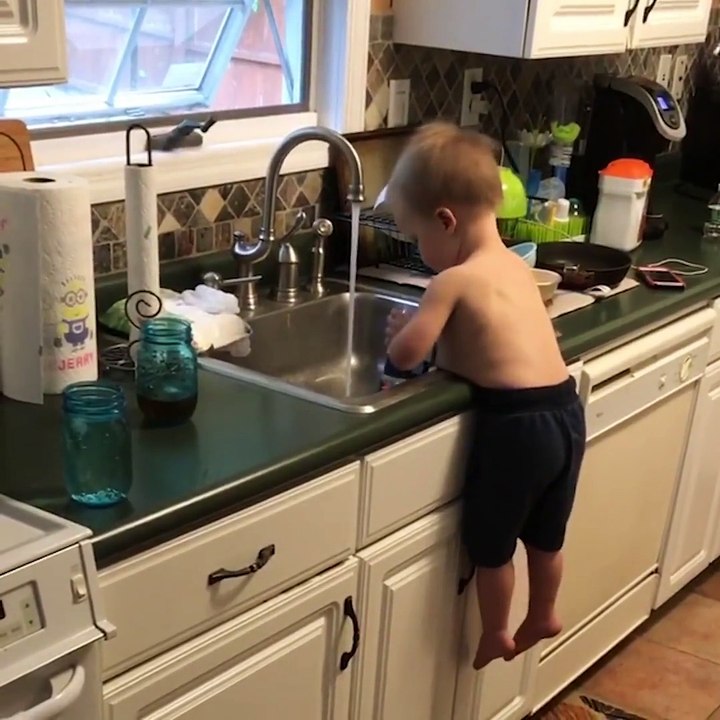 Bien calé sur son ventre, ce bébé fait la vaisselle! Adorable