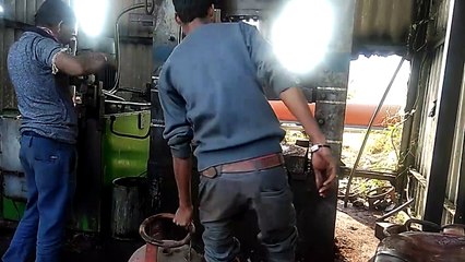 Il s'amuse à mettre une bouteille de gaz dans une presse.